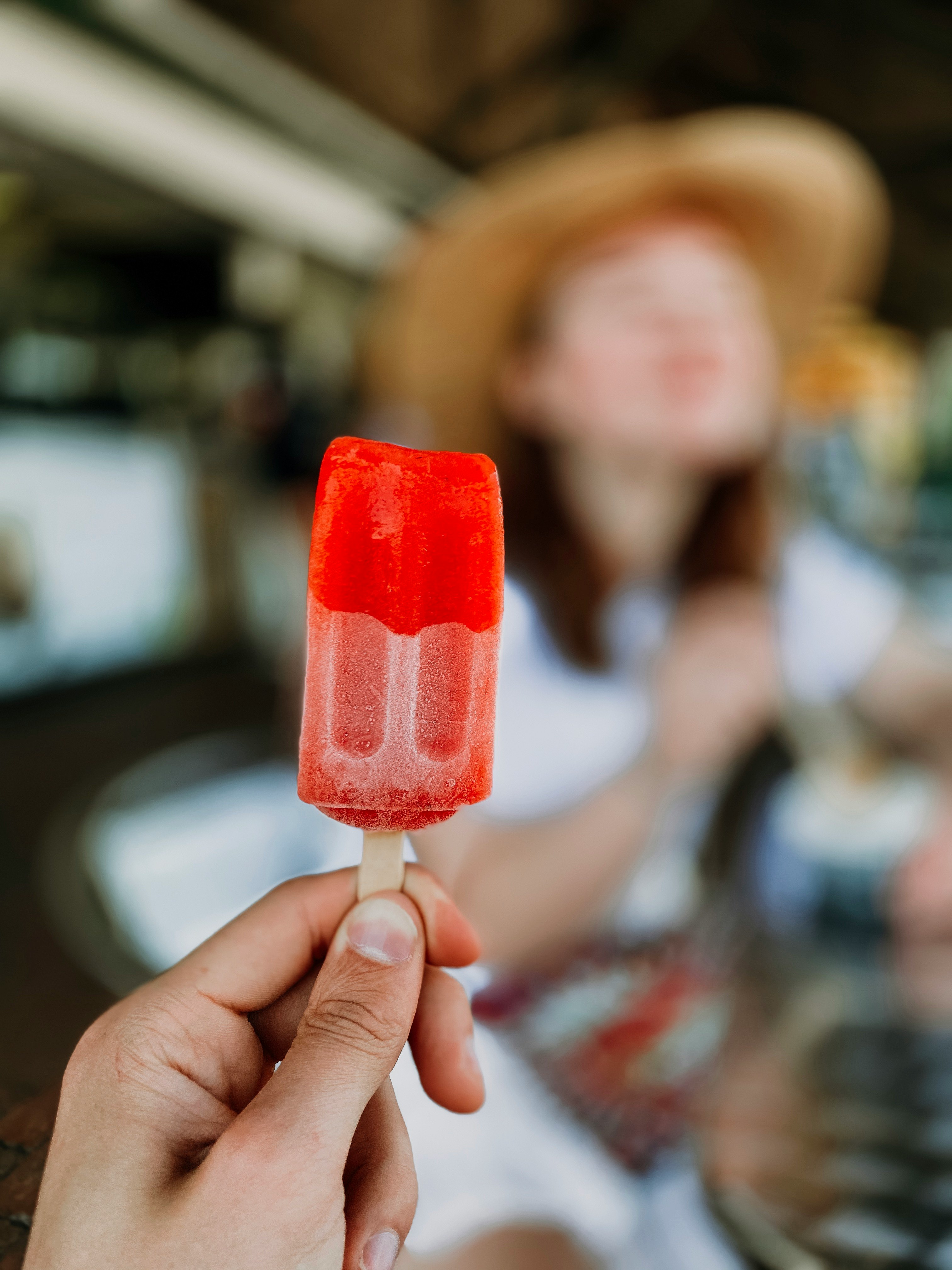 person holding red ice pop